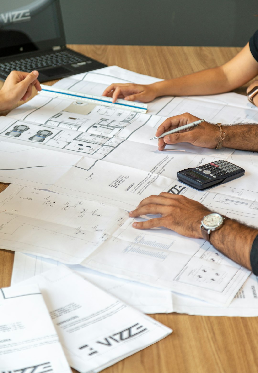Mastering the First Impression: Your intriguing post title goes here people-reviewing-architectural-blueprints-on-desk-3qzmbrvceyq